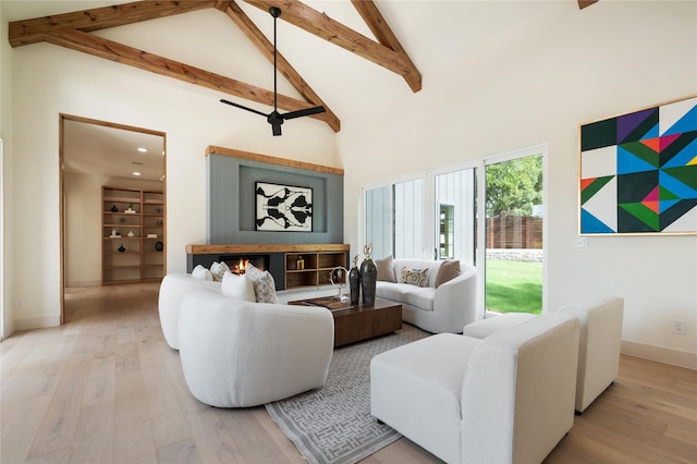 living room with hardwood / wood-style flooring, high vaulted ceiling, beamed ceiling, and ceiling fan