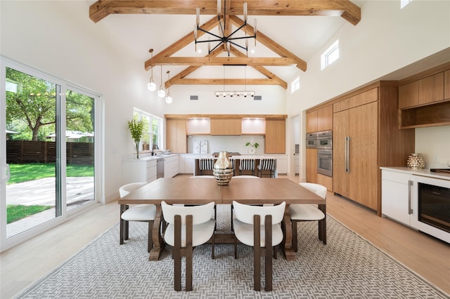 dining space with beamed ceiling, wine cooler, light wood-type flooring, a chandelier, and high vaulted ceiling