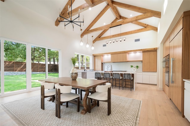 dining room featuring an inviting chandelier, beamed ceiling, light hardwood / wood-style flooring, and high vaulted ceiling