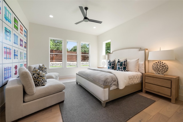 bedroom featuring ceiling fan, multiple windows, and light wood-type flooring