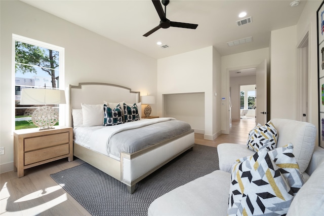 bedroom with light hardwood / wood-style flooring, multiple windows, and ceiling fan