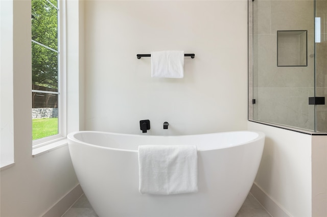 bathroom with tile patterned floors and a bathtub