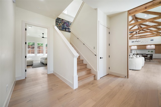 stairs with hardwood / wood-style floors, vaulted ceiling with skylight, and ceiling fan