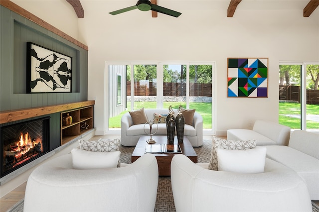 living room featuring beamed ceiling, hardwood / wood-style flooring, a healthy amount of sunlight, and ceiling fan