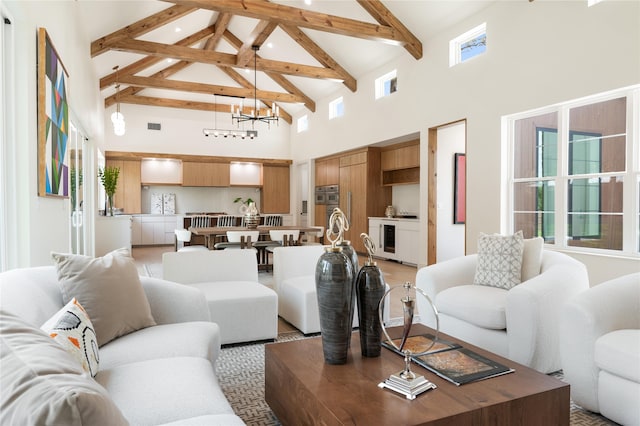 living room with an inviting chandelier, wine cooler, beam ceiling, and high vaulted ceiling