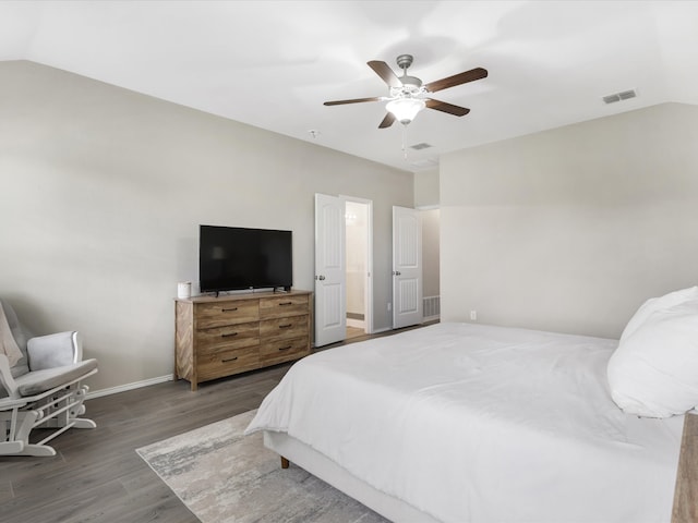 bedroom with dark hardwood / wood-style flooring, vaulted ceiling, and ceiling fan