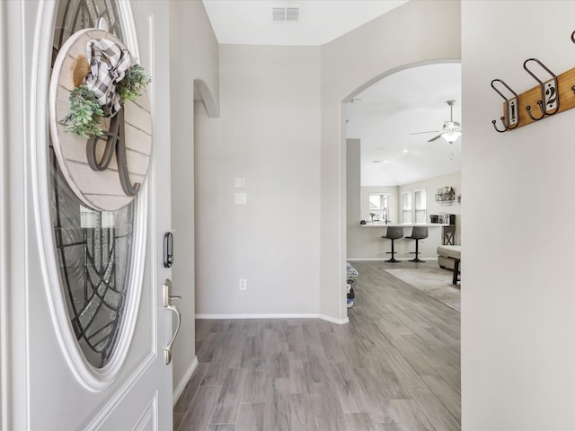 entryway with ceiling fan, light hardwood / wood-style floors, and lofted ceiling