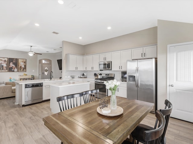 dining area with light hardwood / wood-style flooring, ceiling fan, and sink