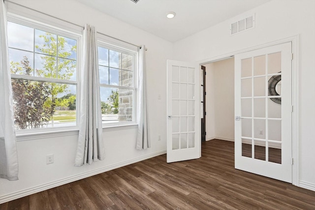 spare room featuring dark wood-type flooring and french doors