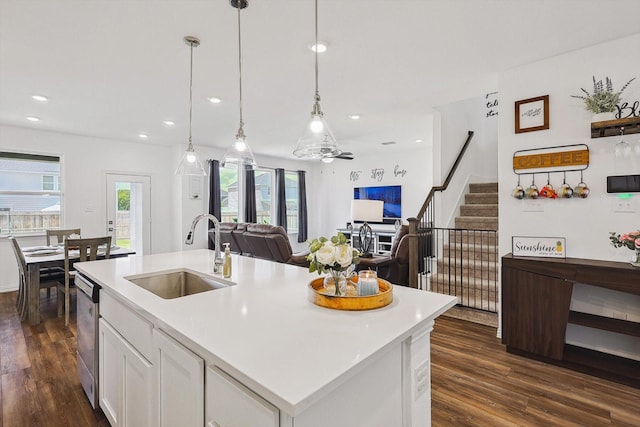 kitchen featuring pendant lighting, a center island with sink, white cabinets, sink, and stainless steel dishwasher