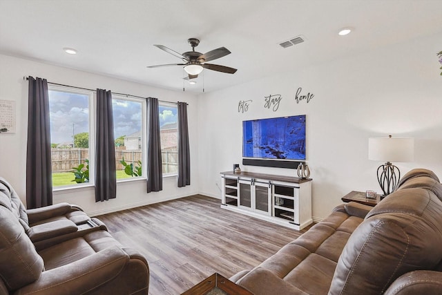 living room featuring light hardwood / wood-style floors and ceiling fan