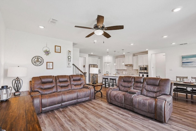 living room featuring ceiling fan and light hardwood / wood-style flooring