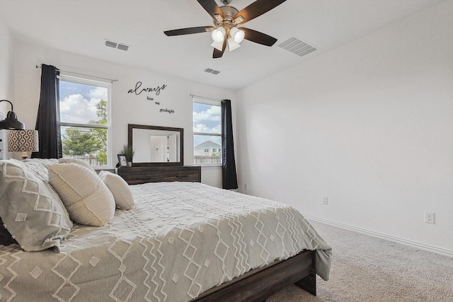 carpeted bedroom with multiple windows and ceiling fan