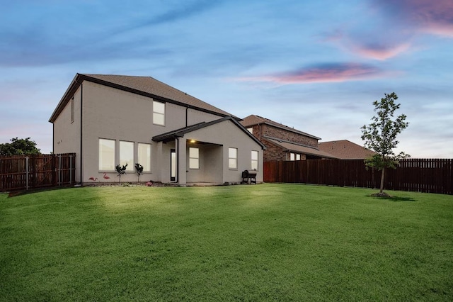 back house at dusk with a yard