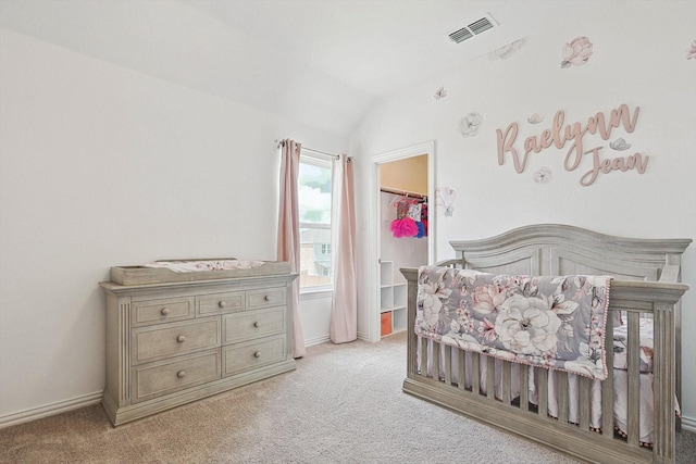 bedroom with light carpet, a spacious closet, and lofted ceiling