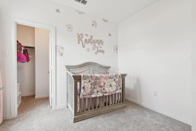 carpeted bedroom featuring a crib