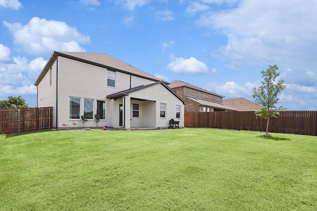 rear view of house featuring a lawn