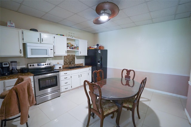 kitchen with electric range, a paneled ceiling, white cabinetry, and black refrigerator with ice dispenser