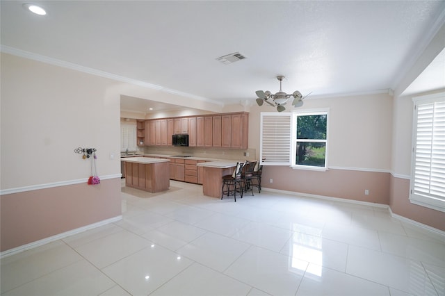 kitchen featuring a center island, crown molding, and a healthy amount of sunlight