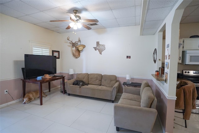 living room featuring a paneled ceiling and ceiling fan