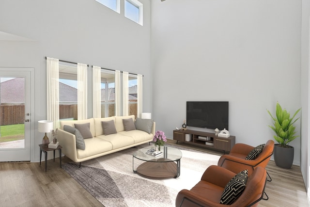 living room featuring light hardwood / wood-style flooring and a towering ceiling