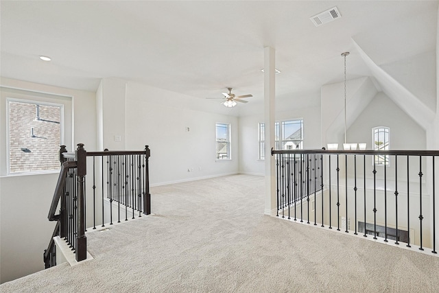 hall featuring carpet floors, lofted ceiling, and a healthy amount of sunlight