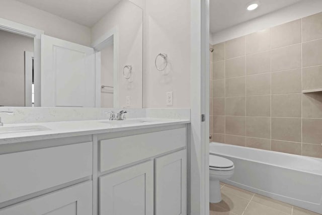 full bathroom featuring tile patterned flooring, vanity, toilet, and tiled shower / bath