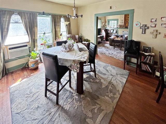 dining area with a chandelier, cooling unit, and dark hardwood / wood-style flooring