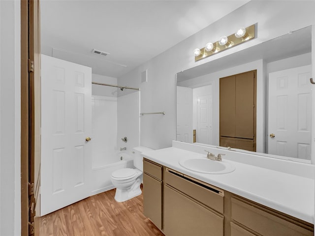 full bathroom featuring toilet, vanity, bathtub / shower combination, and hardwood / wood-style floors