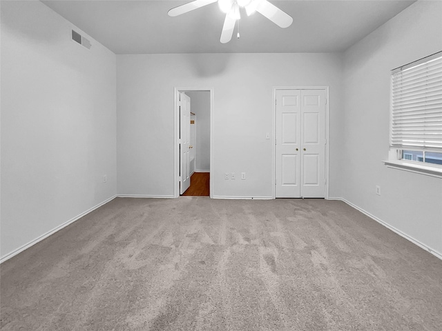 unfurnished bedroom with light colored carpet, ceiling fan, and a closet