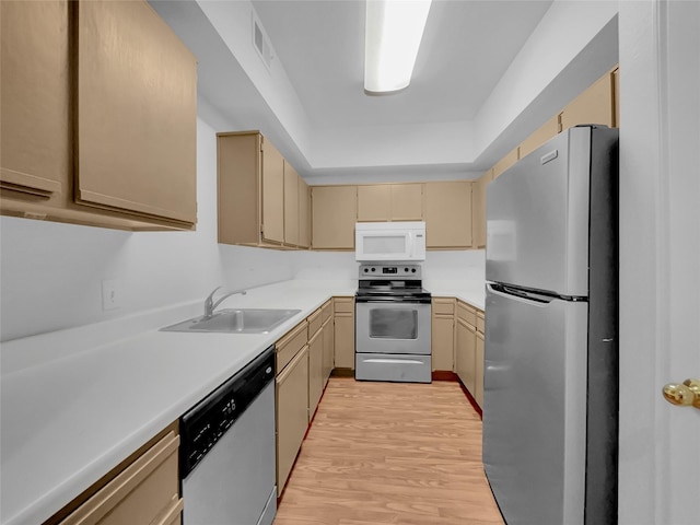 kitchen with appliances with stainless steel finishes, light hardwood / wood-style flooring, light brown cabinets, and sink