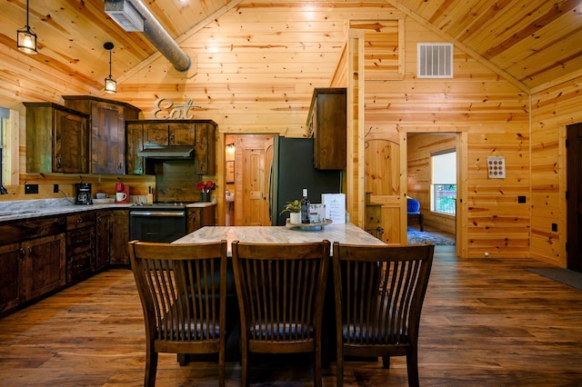 kitchen featuring wooden walls, black refrigerator, range, and hardwood / wood-style flooring