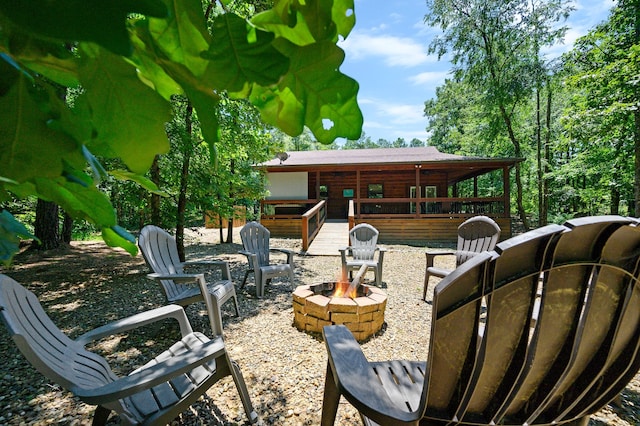 exterior space with a wooden deck and an outdoor fire pit