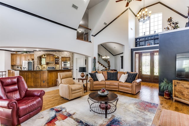 living room with an inviting chandelier, plenty of natural light, and light hardwood / wood-style floors