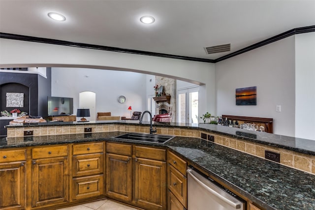 kitchen featuring light tile patterned flooring, dishwasher, sink, dark stone counters, and ornamental molding