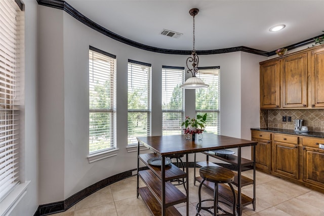 tiled dining space featuring crown molding