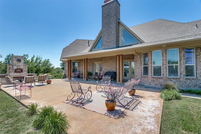 rear view of property featuring a fireplace and a patio area