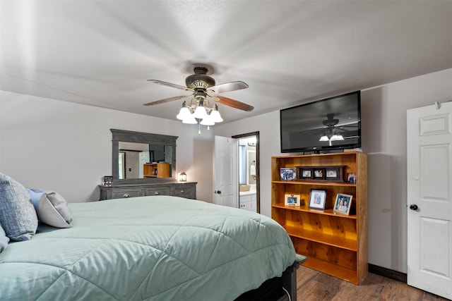 bedroom with ceiling fan, ensuite bathroom, and dark wood-type flooring