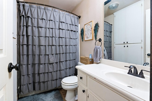 bathroom featuring a shower with curtain, toilet, and vanity