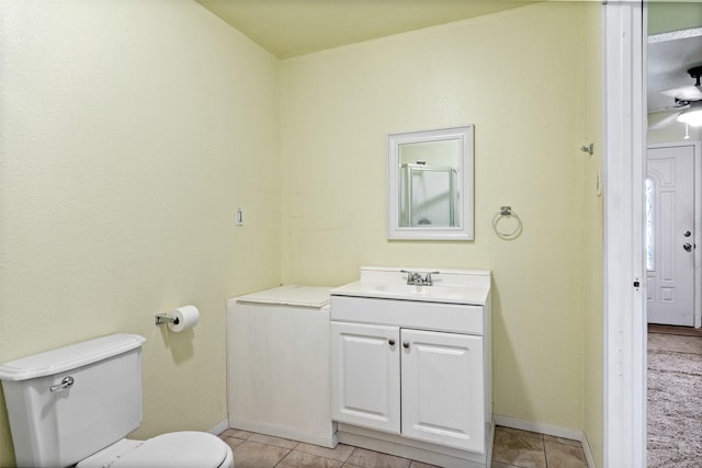 bathroom with tile patterned flooring, vanity, toilet, and ceiling fan