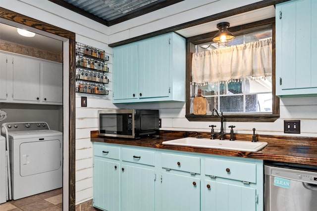 kitchen with washer and dryer, wooden counters, stainless steel appliances, and sink