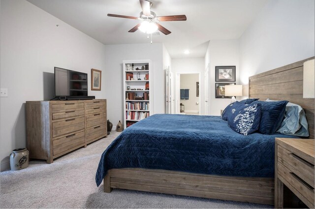 bedroom featuring light carpet, connected bathroom, and ceiling fan