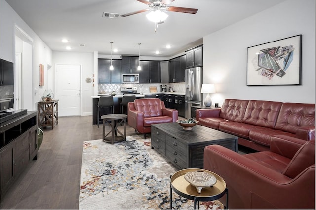 living room featuring hardwood / wood-style floors and ceiling fan