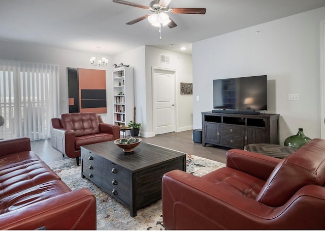 living room with ceiling fan with notable chandelier