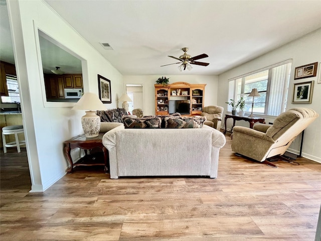 living room with ceiling fan and light hardwood / wood-style floors