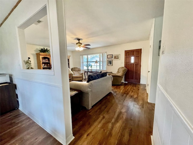 living room with ceiling fan and dark hardwood / wood-style flooring