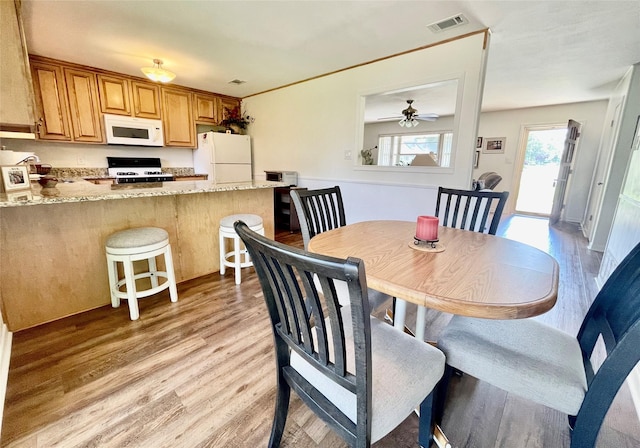 dining area with ceiling fan and light hardwood / wood-style flooring