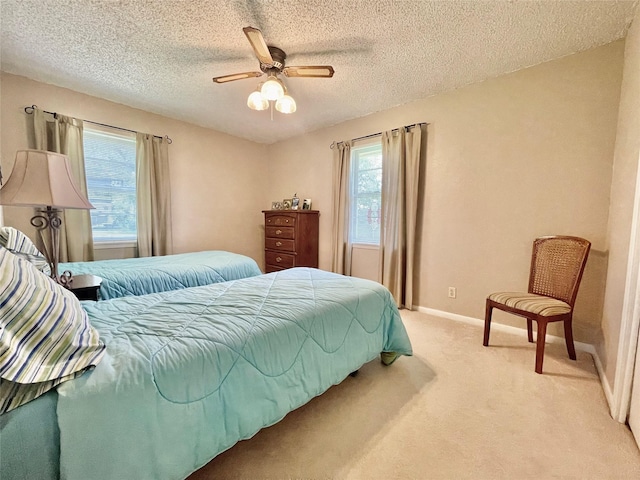 carpeted bedroom featuring ceiling fan and a textured ceiling