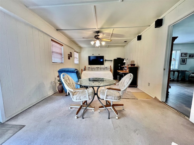 carpeted dining space with ceiling fan