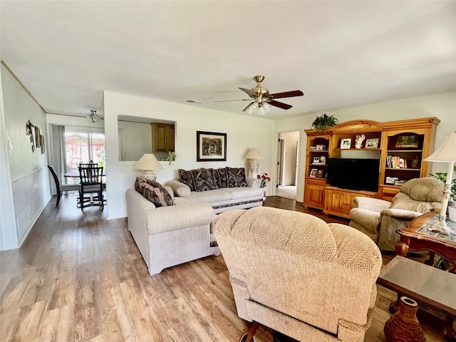 living room featuring ceiling fan and hardwood / wood-style flooring